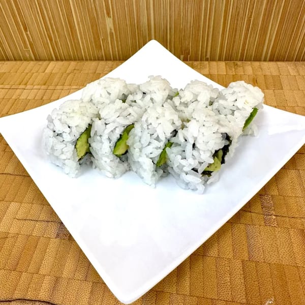 Six pieces of Sawara Sushi's avocado roll, with white rice and green avocado, on a white plate.