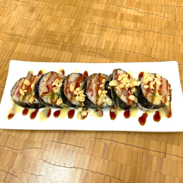 Sawara Sushi's sushi rolls with sauce and crispy toppings on a white rectangular plate.
