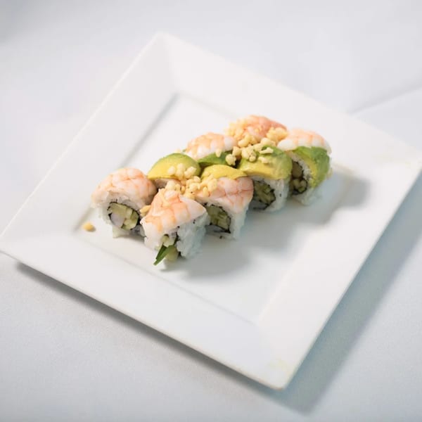 Sawara Sushi's shrimp and avocado sushi rolls, topped with crunchy tempura flakes, on a white plate.
